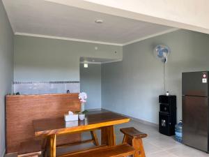 a dining room with a table and a refrigerator at Rumah Harmoni in Ungasan