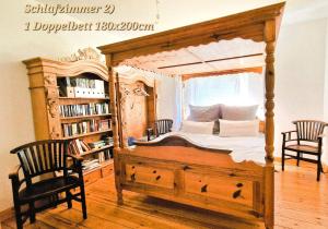 a bedroom with a large wooden bed with two chairs at Scheunenloft Usedom -3- Familienoase bis 6 Pax spacious big garden dog-friendly - SiLyVi homes in Mellenthin +22 photos