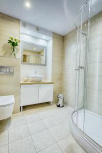 a bathroom with a toilet and a sink and a shower at TK Apartments Spiżowa in Wrocław +17 photos