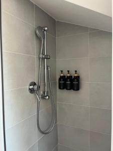una ducha con 3 botellas en la pared en el baño en Mansarda Lucia, en Parma