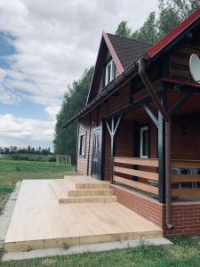 a house with a porch and stairs in front of it at Domek wolnostojący na terenie Hotelu Trzy Podkowy in Biskupiec