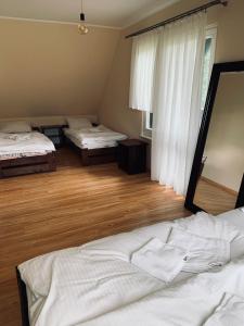 a bedroom with two beds and a large mirror at Domek wolnostojący na terenie Hotelu Trzy Podkowy in Biskupiec +25 photos