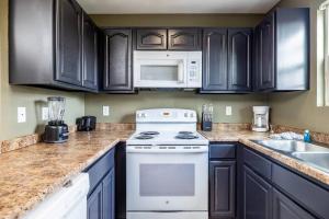 a kitchen with black cabinets and a white stove at Charming Hideaway near Dolly w Hot tub & Arcade in Sevierville