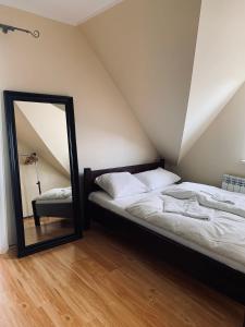 a mirror sitting next to a bed in a attic at Domek wolnostojący na terenie Hotelu Trzy Podkowy in Biskupiec