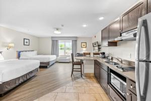 a hotel room with a kitchen and a bedroom at Independence Stay Long Term and Suites in Marinette