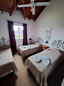 a bedroom with two beds and a ceiling fan at Vista Bella Cabañas in La Falda