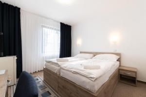 ein Schlafzimmer mit einem großen Bett mit weißer Bettwäsche in der Unterkunft Hotel Širák in Most