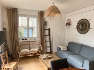a living room with a blue couch and a window at Fécamp Beachfront House in Fécamp