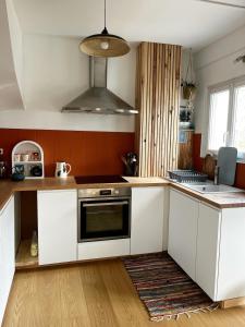 a kitchen with white cabinets and a stove top oven at Fécamp Beachfront House in Fécamp