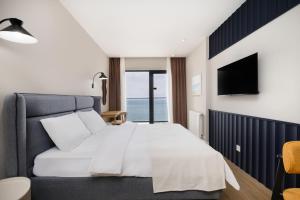 a bedroom with a large bed and a television at Next White Aparthotel OFFICIAL in Batumi +7 photos