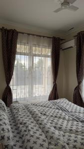 a bedroom with a large bed and a window at Casa Tranquila Airpot Transit Stay in Dar es Salaam +23 photos