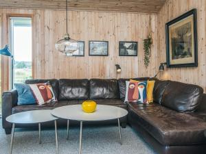 a living room with a leather couch and a table at 8 person holiday home in Ebeltoft in Ebeltoft +41 photos