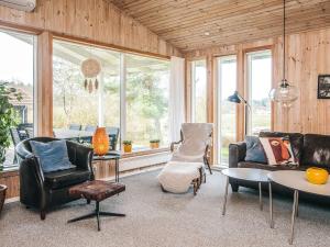 a living room with leather furniture and windows at 8 person holiday home in Ebeltoft in Ebeltoft