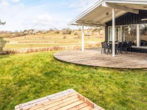 a deck with a table and chairs on a house at 8 person holiday home in Ebeltoft in Ebeltoft