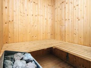 a wooden sauna with a tub with rocks in it at 8 person holiday home in Ebeltoft in Ebeltoft