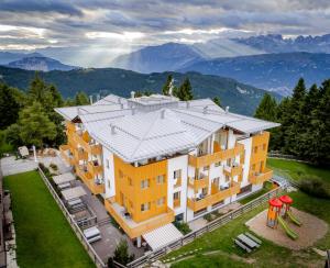 an aerial view of a building with mountains in the background at Hotel Alpine Mugon in Vason
