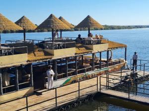 a boat on the water with people on the deck at Mukuni Villas in Livingstone