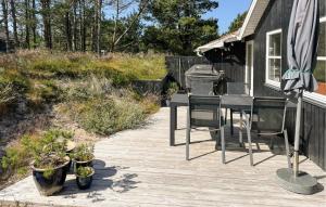 a deck with a table and chairs and an umbrella at 3 Bedroom Cozy Home In Thisted in Thisted