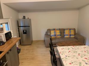a living room with a couch and a table and a kitchen at Appartement 3 pièces dans une maison au calme in Bonneville