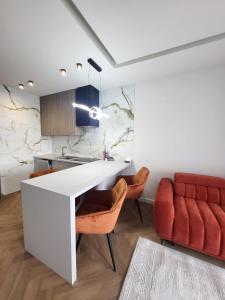 a kitchen with a white counter and a red couch at Apartaments by Ola in Radom +5 photos