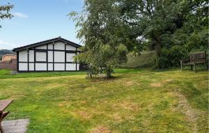 a black and white building in a field with a bench at Amazing Home In Meschede With Wifi in Meschede +22 photos