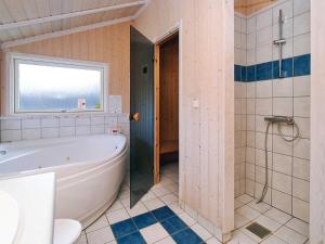 uma casa de banho com uma banheira e um chuveiro com uma janela em 7 person holiday home in Asnæs-By Traum em Asnæs