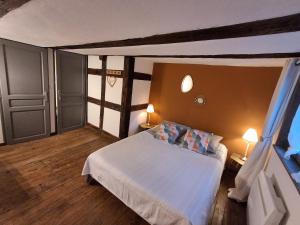 a bedroom with a white bed and two lamps at Gite le 1788 in Scherwiller