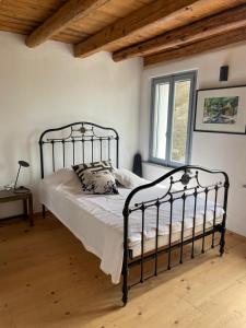 a bedroom with a black metal bed in a room at Casale nel mezzo dei vigneti in Caneva