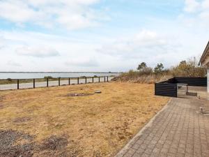 a building with a bench next to a body of water at 8 person holiday home in Vestervig-By Traum in Vestervig