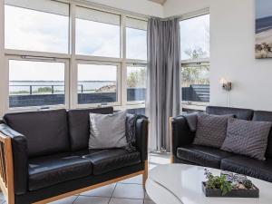 a living room with two black leather couches and a table at 8 person holiday home in Vestervig-By Traum in Vestervig +15 photos