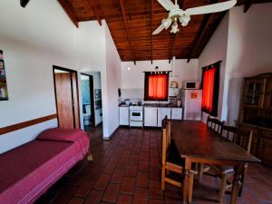 a living room with a table and a kitchen at Vista Bella Cabañas in La Falda