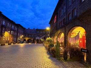 une rue pavée dans une ville la nuit dans l'établissement Nikisz Red BDSM, à Katowice