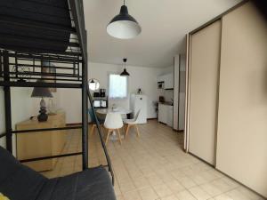 a living room and kitchen with a table and chairs at Maison de vacances en Bretagne à 900 m de la plage - 5 personnes - Piscine chauffée in Erdeven +6 photos