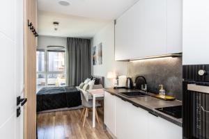 a kitchen with a sink and a bed in a room at Super-Apartamenty Plac Wolności 6 in Poznań +12 photos