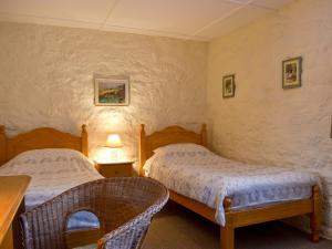 a bedroom with two beds and a table at Lower Chinkwell-Uk12426 in Widecombe in the Moor