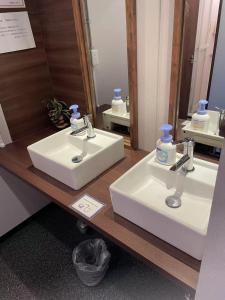 Un mostrador de baño con dos lavabos y un espejo. en ehostel心斎橋 2人ROOM, en Osaka