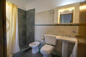 a bathroom with a toilet and a sink and a shower at Vista Bella Cabañas in La Falda +65 photos