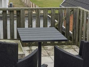 a picnic table and two chairs on a balcony at 6 person holiday home in Lemvig-By Traum in Ferring