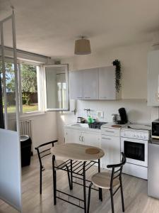 a kitchen with a table and some chairs and a table and a table at Urban Stay Rennes - Logement entier à Saint-Jacques de la Lande in Saint-Jacques-de-la-Lande