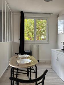 a kitchen with a table and chairs and a window at Urban Stay Rennes - Logement entier à Saint-Jacques de la Lande in Saint-Jacques-de-la-Lande