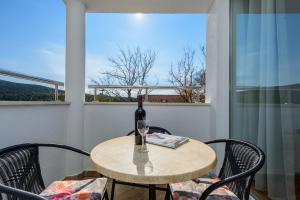 a table with a bottle of wine and a glass at Apartment Ana-Marija in Cavtat