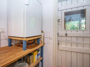 a kitchen with a refrigerator on a shelf next to a door at 4 person holiday home in Bryrup-By Traum in Bryrup