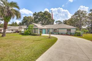 a house with a palm tree and a driveway at Golf Course Views! Home 10 Mi to Crystal River in Citrus Springs