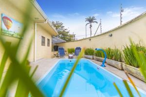 a swimming pool in the backyard of a house at Pousada Boutique Três Marias in Guarujá