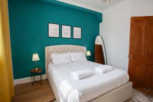 a bedroom with a white bed with a green wall at 1 Bed Cosy Loch Lomond base in Bonhill +8 photos