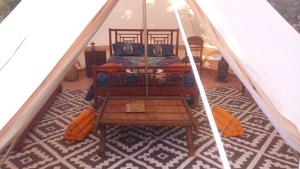 a room with a bed and a table in a tent at tente india in Le Pener