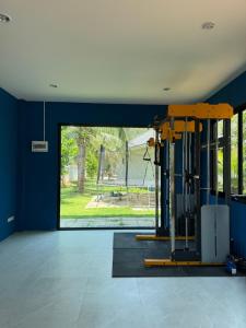 Habitación con gimnasio y ventana grande. en Baan Sam Roi Yot Mountain View Pool Villa, 