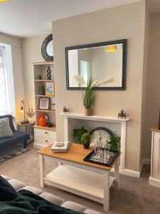 Una sala de estar con una mesa y un espejo. en Lovely house in West Hull, en Hull
