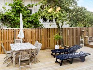 a wooden deck with a table and chairs and an umbrella at 4 star holiday home in Dyrön in Stora Dyrön