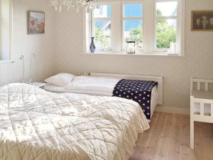 two beds in a bedroom with two windows at 4 star holiday home in Dyrön in Stora Dyrön